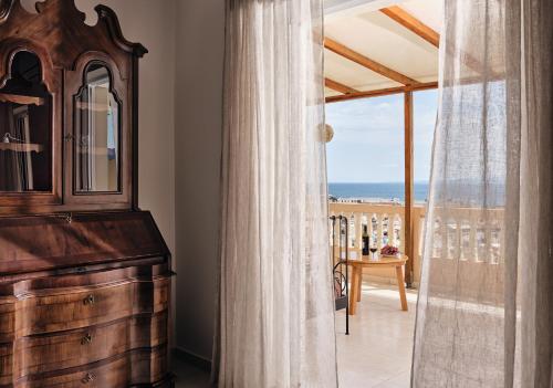 a room with a dresser and a view of the ocean at THREE GRACES Apartments ZAKYNTHOS TOWN in Zakynthos Town