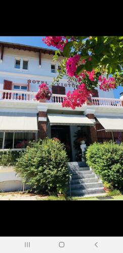 - un grand bâtiment blanc avec des fleurs roses dans l'établissement Studio avec terrasse vue Tourmalet dans Villa historique 