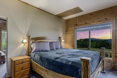 sypialnia z łóżkiem i dużym oknem w obiekcie This is the ultimate in private escape w mieście Ponca
