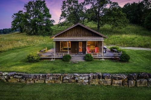 a small cabin on a hill with a green field at This is the ultimate in private escape in Ponca