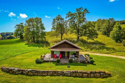 a small house on a hill with a green field at This is the ultimate in private escape in Ponca