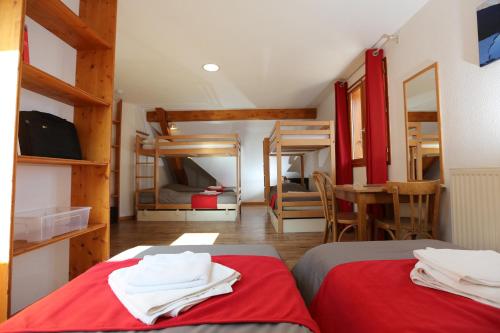 une chambre avec deux lits et une table dans une pièce dans l'établissement Auberge d+ Valloire-Galibier, à Valloire