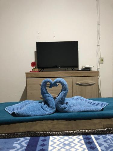 two swans are forming a heart on a bed at Lar doce lar da Neuza in Campos do Jordão