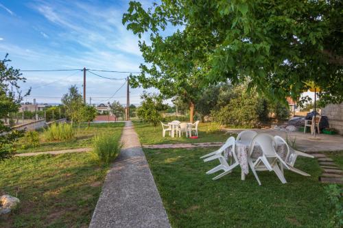 a table and chairs sitting in the grass at Kostas & Eleni Apartments in Sotirítsa