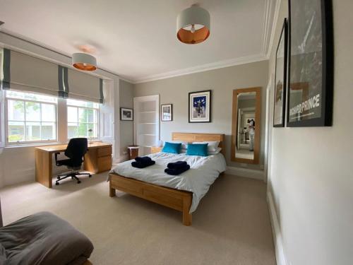 1 dormitorio con cama con almohadas azules y escritorio en Lade Braes Lane, Westview House, Westview, St. Andrews, Fife, KY16 9ED en St Andrews