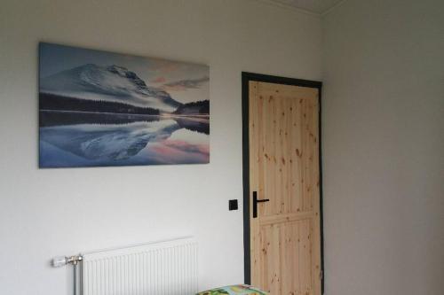 1 dormitorio con una foto en la pared junto a una puerta en luxe Vakantie bungalow met 3 slaapkamers, en Dronrijp