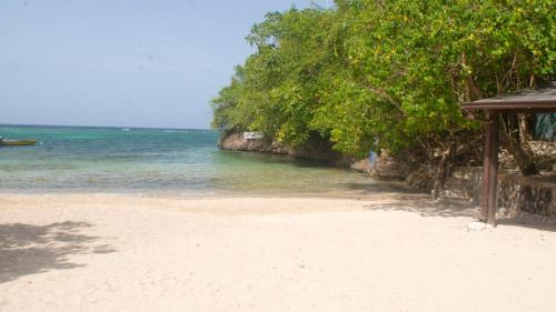 a sandy beach with a hut and the ocean at Sunset Nabro in St Mary