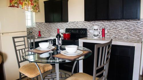 a kitchen with a glass table with chairs and a counter at Sunset Nabro in St Mary