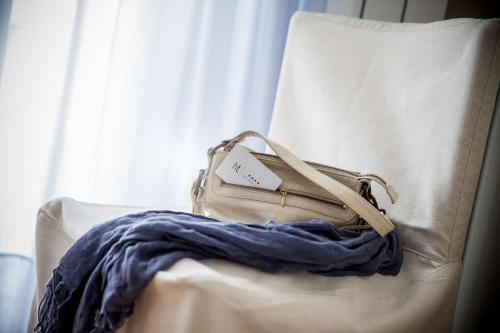 a tan purse sitting on top of a couch at Hotel Torino Wellness & Spa in Diano Marina