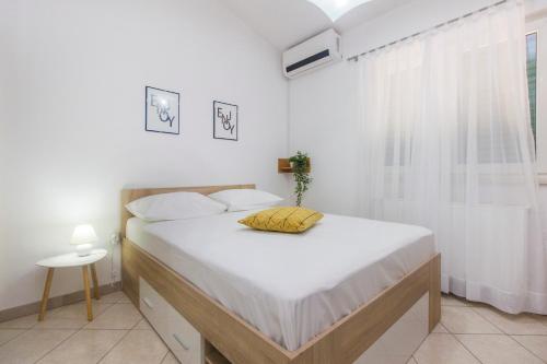 um quarto branco com uma cama grande e uma janela em Top Of The City em Sibenik