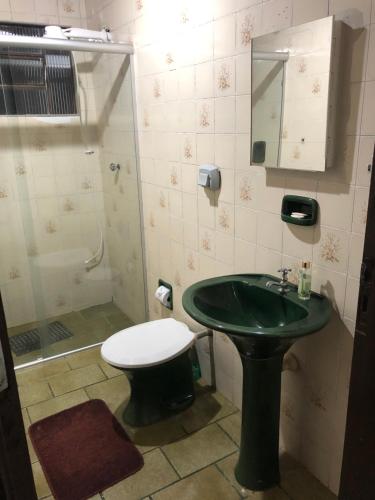 a bathroom with a green sink and a shower at Lar doce lar da Neuza in Campos do Jordão