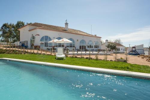 a house with a swimming pool in front of a house at Escola do Fado in Vila Fernando