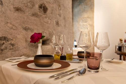 a table with wine glasses and a red rose on it at Hotel de Charme Römerhof in Arbon