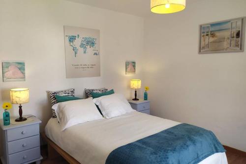 a bedroom with a bed with two night stands and two lamps at Villa Terra da Eira T1 - Sun, Sea and Relax in Lourinhã