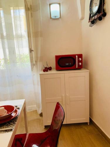 a red microwave sitting on top of a cabinet in a kitchen at Perla Barocca Centro Storico Mesagne in Mesagne