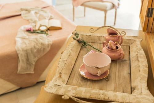 a tray with a tea pot and a tea set on a table at B&B Antico Telaio in Santa Maria Navarrese