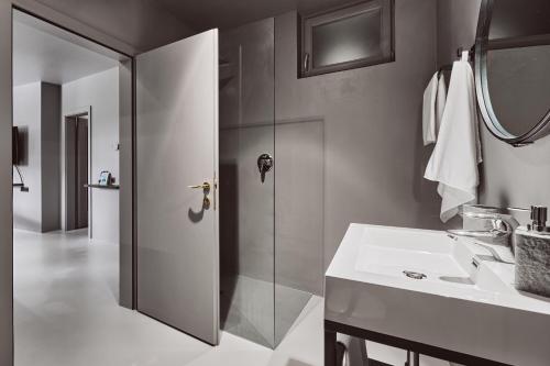uma casa de banho com um chuveiro e um lavatório branco em Stufels 7 Design Apartment with Brixen Card em Bressanone