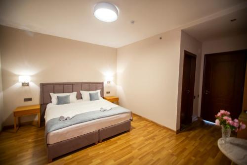 a bedroom with a bed with two towels on it at Chveni Ezo Boutique Hotel in K'obulet'i