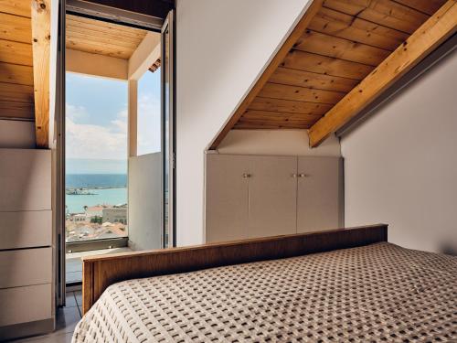 a bedroom with a bed and a large window at THREE GRACES Apartments ZAKYNTHOS TOWN in Zakynthos Town