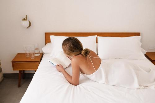 a woman sitting on a bed looking at a tablet at CASA SIRFANTAS in Córdoba