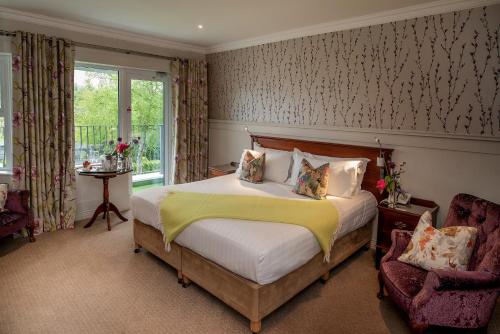 a bedroom with a large bed and two chairs at Whitford House Hotel in Wexford