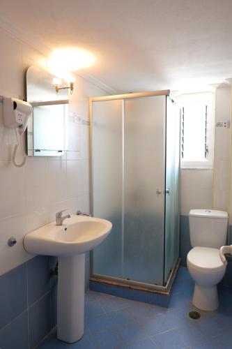 a bathroom with a shower and a sink and a toilet at Miracle Apartments Saranda in Sarandë