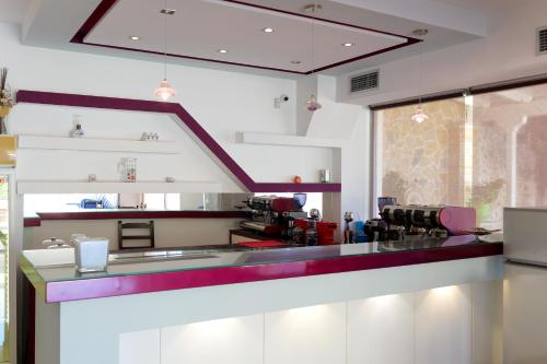 a kitchen with a bar with red and white at Miracle Apartments Saranda in Sarandë