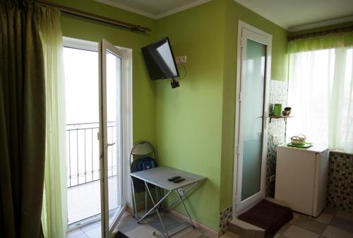 um quarto com uma pequena mesa e uma televisão na parede em Лиманский Берег em Zatoka