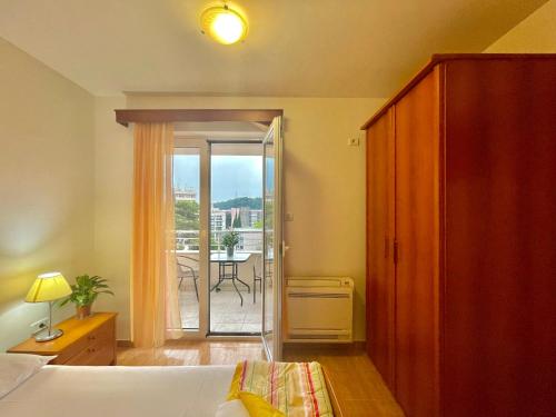 a bedroom with a bed and a door to a balcony at Apartments Boreta Becici in Budva