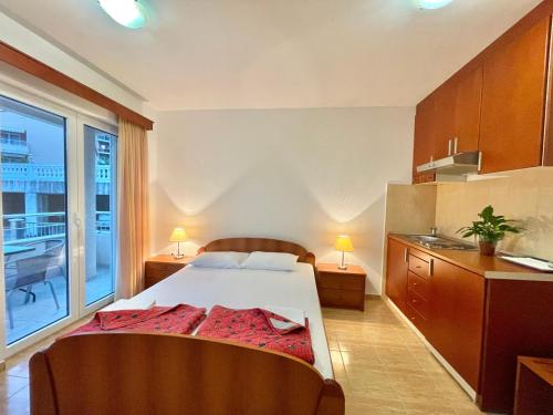 a bedroom with a bed and a large window at Apartments Boreta Becici in Budva