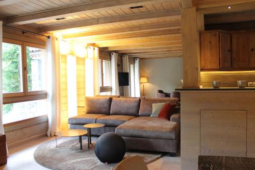 een woonkamer met een bank en een tafel bij Chalet Les 5 Sapins in Les Allues