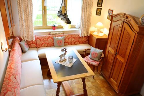 a living room with a couch and a table at Haus Moderegger in Bischofswiesen