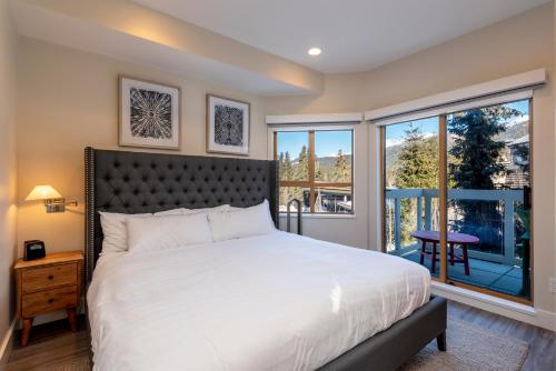 um quarto com uma cama grande e uma varanda em Amazing Village Condo with unparalleled Mountain Views overlooking the Olympic Plaza em Whistler