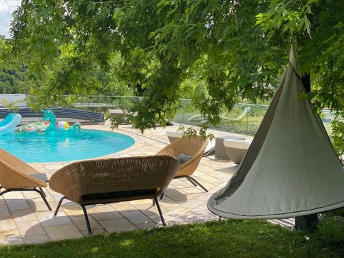 une terrasse avec une piscine, des chaises et un parasol dans l'établissement The Panoramic, à Pringy