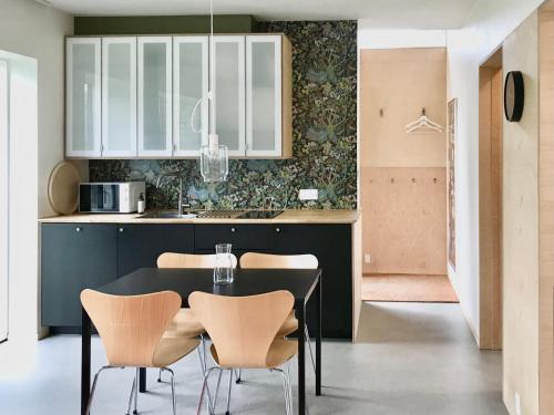 哥本哈根的住宿－Villa Stjerneklar，厨房配有黑色的桌子和椅子