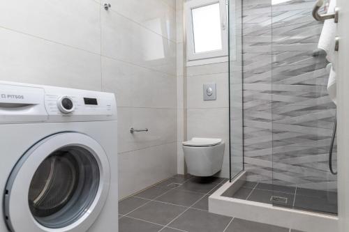 a bathroom with a washing machine and a toilet at AZUR in Naxos Chora