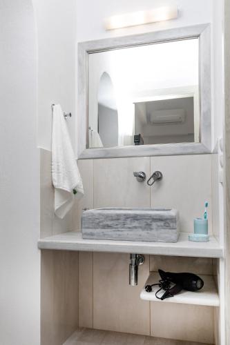 a bathroom with a sink and a mirror at AZUR in Naxos Chora