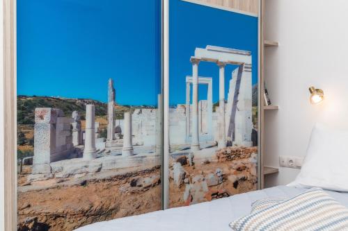 a bedroom with a view of the ruins of a city at AZUR in Naxos Chora