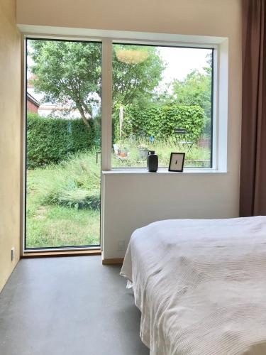 a bedroom with a bed and a large window at Villa Stjerneklar in Copenhagen