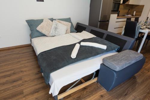 uma cama num quarto com um repousa-pés azul em ÁbraApartman em Siófok