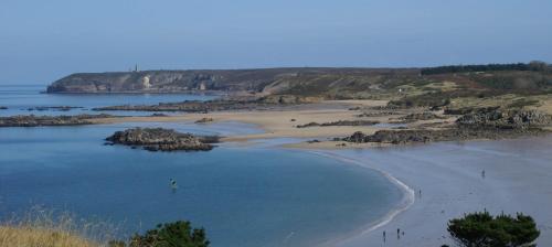 a view of a beach with rocks in the water at Gîte Charbonnerie in Moncontour