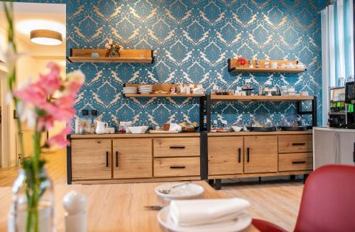 una cocina con armarios de madera y una pared azul en Boutique-Hotel Villa Anna en Eisenach