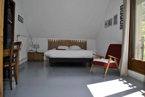 a bedroom with a bed and a chair at AUBERGE GAILLARD in La Motte-en-Champsaur