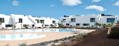 a resort with a swimming pool and white buildings at CASA UMA in Villaverde