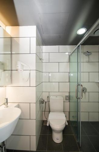 a bathroom with a toilet and a sink at Sense Hotel Taiping in Taiping