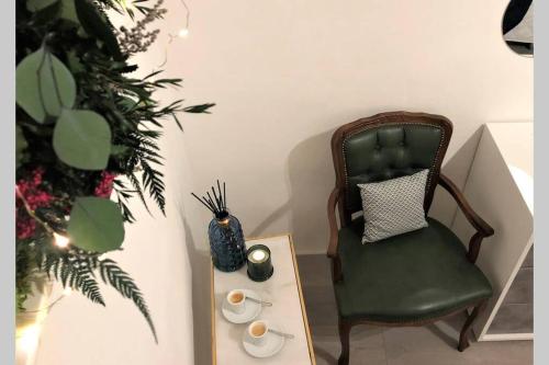 a green chair next to a table and a plant at Le Bijou di Dolceacqua, per un momento memorabile. in Dolceacqua