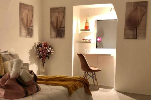 a bedroom with a bed and a chair and a mirror at Le Bijou di Dolceacqua, per un momento memorabile. in Dolceacqua