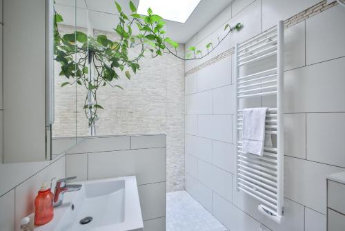 une salle de bain blanche avec un lavabo et un miroir dans l'établissement Cosy 4P FullEquiped/Jardin des Plantes/La Sorbonne, à Paris