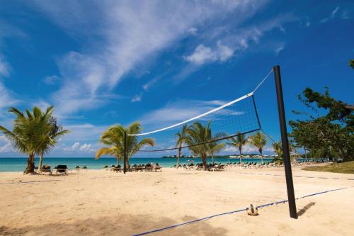 a volley ball net on a beach with palm trees at Riu Palace Tropical Bay - All Inclusive in Negril
