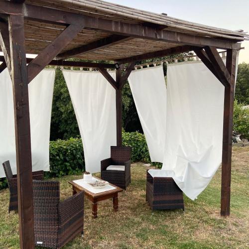 a wooden pergola with chairs and a table at B&B La Tasgia in Aggius